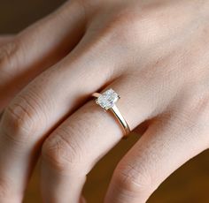 a woman's hand with a diamond ring on it