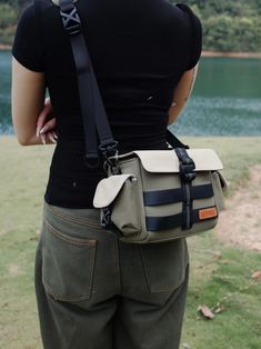 a woman is standing with her back to the camera holding a small bag in her hands