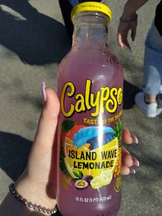 someone holding up a bottle of calypps island wave lemonade