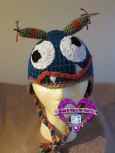 a crocheted hat with eyes and horns on top of a mannequin head