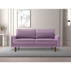 a purple couch sitting on top of a rug