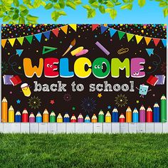 a welcome back to school sign in front of a fence with colorful crayons