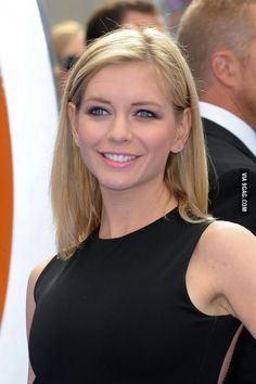 a woman in a black dress smiling for the camera