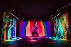 a brightly lit room with colorful lights on the walls and a large bottle in the center