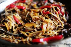 a bowl filled with noodles and meat on top of a table