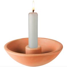 a candle is lit in a clay bowl