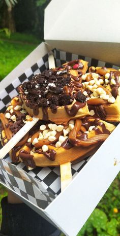 a box filled with lots of food on top of a checkerboard table cloth