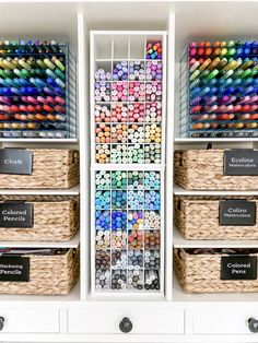 an organized craft room with lots of different colored crayons in baskets and labels