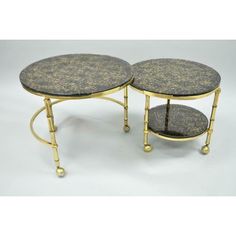 two tables with marble top and gold metal legs, one on each side is holding a tray