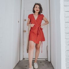 a woman standing in front of a white door