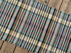 a plaid rug is laying on a wooden floor