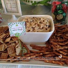 crackers and dip in a white bowl on a tray with a green ribbon around it