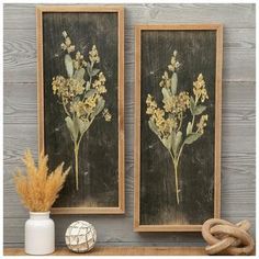 two framed pictures with yellow flowers are on a shelf next to a vase and rope