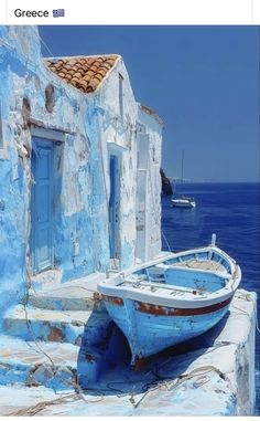 an old boat sitting on the side of a building next to the ocean in greece