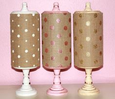 three lamps are lined up against a pink wall with polka dot fabric coverings on them