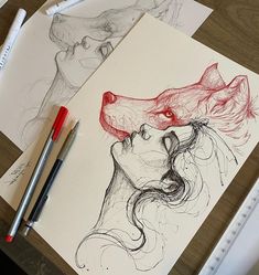 a drawing of a woman's face with a wolf head on it, next to markers and pencils