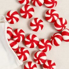 several red and white candy canes are on the table next to a cloth bag