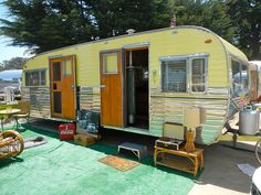 a yellow and silver trailer parked on top of a grass covered field