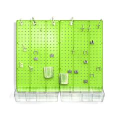 a green pegboard wall with hooks and clips on the bottom, hanging from it's sides