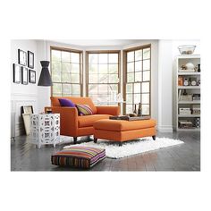 an orange couch sitting in front of a window