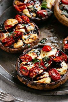 baked mushrooms with tomatoes and mozzarella sauce on a metal platter, ready to be eaten