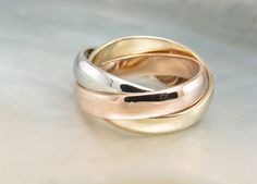 two gold and silver rings sitting on top of each other