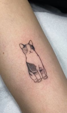 a small cat tattoo on the arm