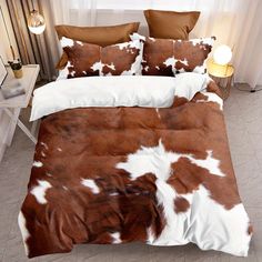 a brown and white cow print comforter on a bed