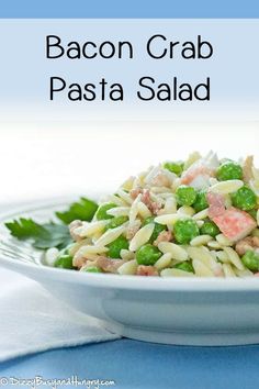 a white bowl filled with pasta salad on top of a blue and white table cloth