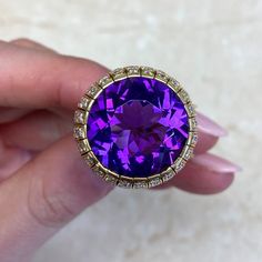 This item has just been reserved by another customer. Please contact us to be notified if it becomes available.  This beautiful Amethyst ring has a round-shaped amethyst with a deep purple color. The amethyst ring weighs approximately 13.54 carats and is set in high-quality 18k yellow gold. The Amethyst ring design is enhanced with a row of dazzling diamonds carefully placed on the gold setting.  This vintage ring originating from the 1970s exudes a timeless charm and showcases the stunning allu Luxury Vvs Clarity Amethyst Ring For Formal Occasions, Luxury Round Amethyst Ring With Gemstone Accents, Luxury Gold Round Amethyst Ring, Luxury Amethyst Ring With Round Cut In Gold, Luxury Hallmarked Round Cut Amethyst Ring, Luxury Hallmarked Amethyst Ring, Luxury Amethyst Gemstones Round Cut, Luxury Round Cut Amethyst Gemstones, Luxury Purple Amethyst 14k Gold Ring