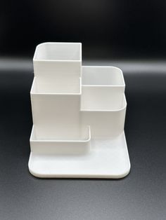 three white dishes stacked on top of each other in front of a black background,