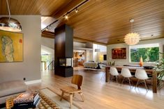 a living room filled with furniture and a fire place in the middle of a wooden floor