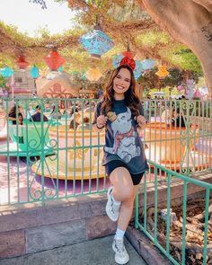 a woman posing in front of an amusement park