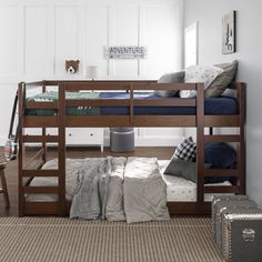 a bunk bed sitting in the middle of a bedroom next to a desk and chair