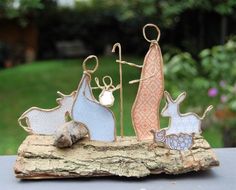 an image of a nativity scene made out of wood and wire on a table