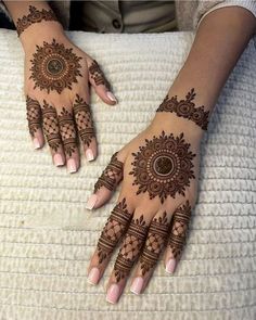 two hands with henna tattoos on them