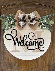 a welcome sign with two bows on it