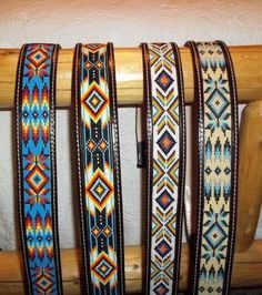 four different colored belts are lined up on a rack