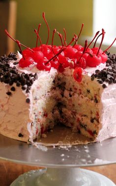 a cake that has been cut in half with cherries on top and chocolate chips around the edges