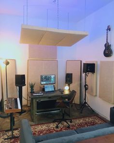 a living room filled with lots of furniture and sound equipment on top of a rug