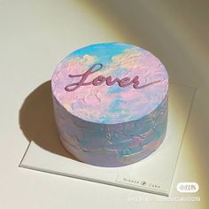 a colorful cake with the word love on it sitting on top of a white table