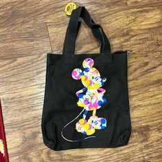 Canvas Disney Tote Black With Blue, Yellow, Pink And White 16.5 X 14.5 Inches 3 Inside Small Pockets Clip To Attach Smaller Bag/Wallet/Etc Nwt Disney Style Black School Bags, Trendy Minnie Mouse Bags For Daily Use, Casual Minnie Mouse Bag For Everyday Use, Disney Black School Bags, Black Mickey Mouse Bag For Disney Fan Events, Disney Mickey Mouse Bags For Disney Fan Events, Cute Mickey Mouse Bag For Daily Use, Cute Mickey Mouse Bags For Everyday Use, Cute Mickey Mouse Bags For Daily Use