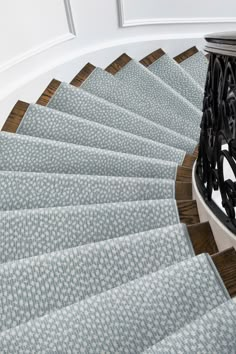 an image of a staircase with carpeted steps going up it's handrail