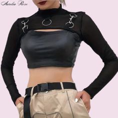 This Trendy Blouse Is All About Making A Bold Statement With Its Snug Fit And Chic Black Shade. The High Collar And Shiny Finish Give It A Sophisticated Yet Cool Vibe, Perfect For Nights Out Or Stylish City Days. It Features Stylish Cut-Outs On The Shoulders And Back, Adding A Funky Twist While Keeping You Cool On The Go. It's An Awesome Pick For Those Who Want To Look Sharp Without Sacrificing Comfort. Decked Out With Silver Rings And Links At The Collar And Shoulders, This Top Mixes A Bit Of I Gothic Stretch Tops For Night Out, Black Cropped Tops For Spring, Gothic Tops For Spring Night Out, Gothic Tops For Night Out In Spring, Black Club Blouse For Spring, Edgy Fitted Crop Top For Spring, Edgy Fitted Crop Top For Fall, Black Crop Top For Club, Edgy Crop Top For Club In Spring