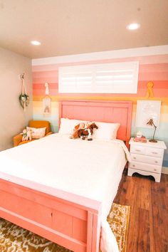 a bedroom with pink, orange and yellow stripes on the walls