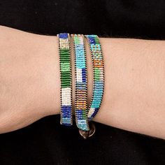 a person's arm with three bracelets on it, one is multicolored