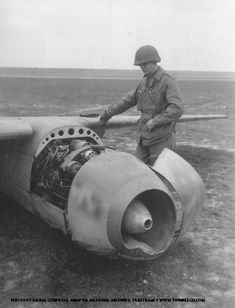 a man standing next to an airplane on top of a field