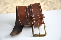 "Vintage brown leather belt, form the 1990s Simple brown leather belt with and aged gold (probably brass) belt buckle and white stitching of the strap. The buckle is marked \" Made in Italy\" on the back and so is the leather strap Size - 85 cm which is 33.5 inch Measurements: Appr. Length - from the edge of the buckle to the first hole (doesn't include the buckle itself) is 30.9 inches / 78.5 cm , to the last hole is 34.8 inches / 88.5 cm. Width of the leather strap - 1.3 inch / 3.3 cm Conditio Hipster Jeans, Womens Leather Belt, Brass Belt, Brass Belt Buckles, Jeans Belt, Gold Belts, Jean Belts, Boho Leather, Brown Leather Belt