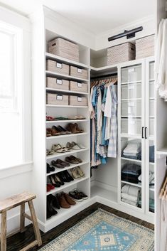 a white closet filled with lots of clothes and baskets on top of it's shelves