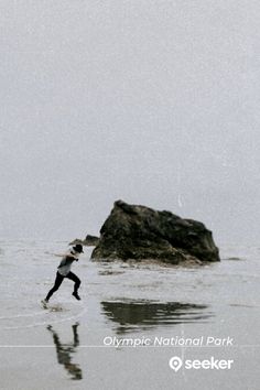 a person is running in the water with a kite